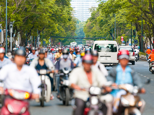 車やバイクが行き交い人々で賑わう、急成長を遂げるベトナムの活気ある風景